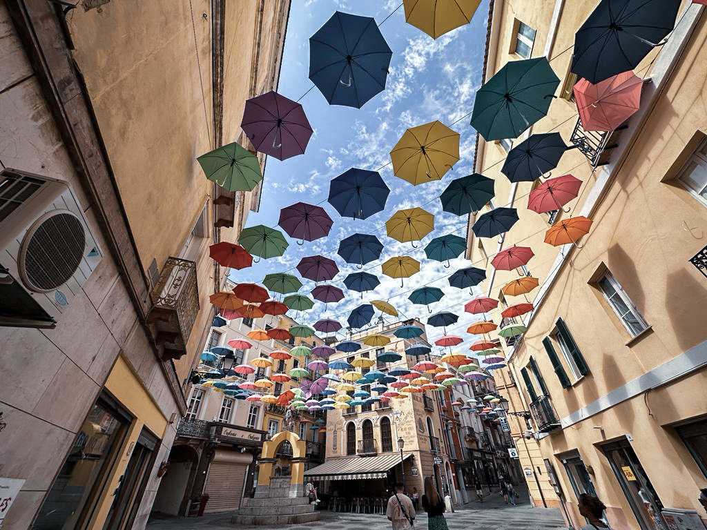 Ein Blick in die wunderschöne Altstadt von Iglesias mit seinen bunten hängenden Schirmen über den Dächern