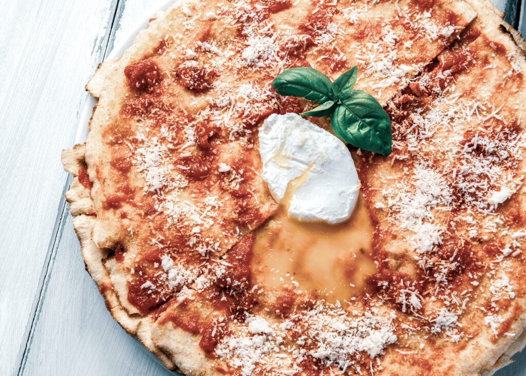 Blick auf die sardische Spezialität Pane Frattau mit Tomaten, Mozzarella und frischem Basilikum - so schmeckt Sardinien im Sommer