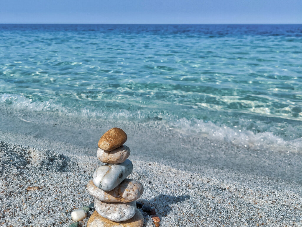 Weißer Quarzsand mit aufgestapelten Steinen am Ufer von Is Arutas – einzigartiger Strand auf Sardinien