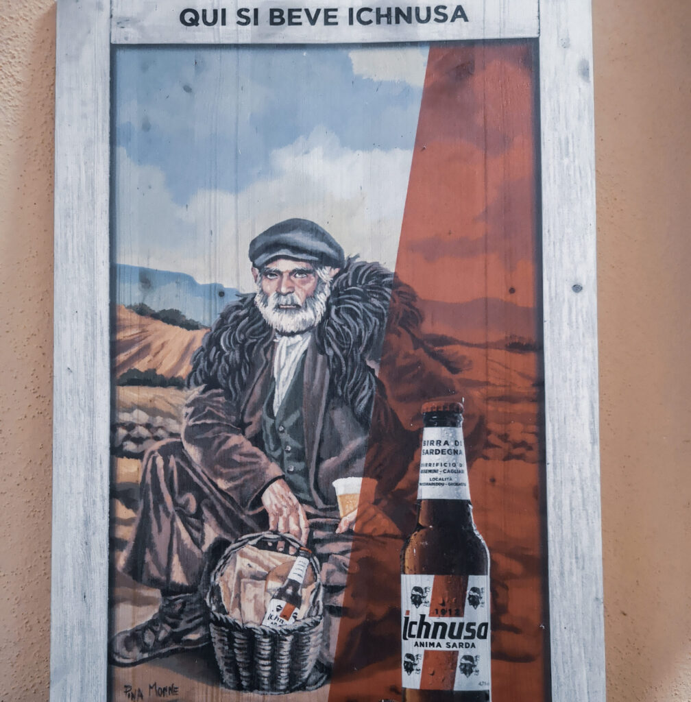 Ein Foto mit Ichnusa Bier Sardinien und einem älteren sardischen Herrn, das in einer Bar an der Wand hängt