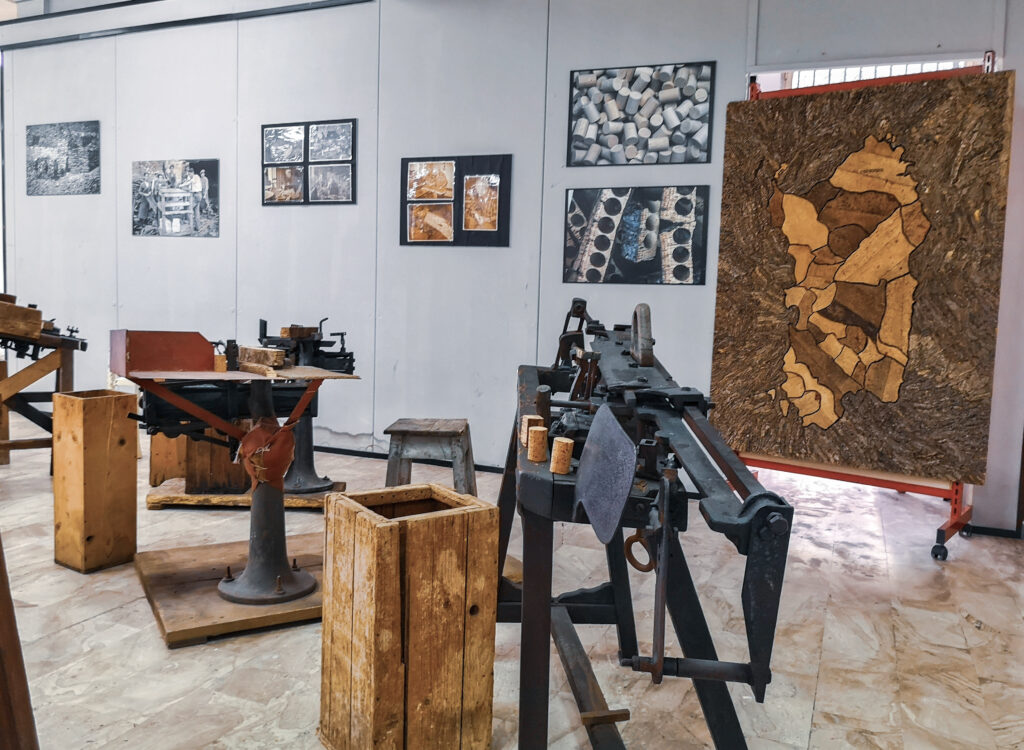 Blick in den Ausstellungsraum des Korkmuseums von Calangianus mit historischen Maschinen, Holzkisten und einer Kork-Karte von Sardinien