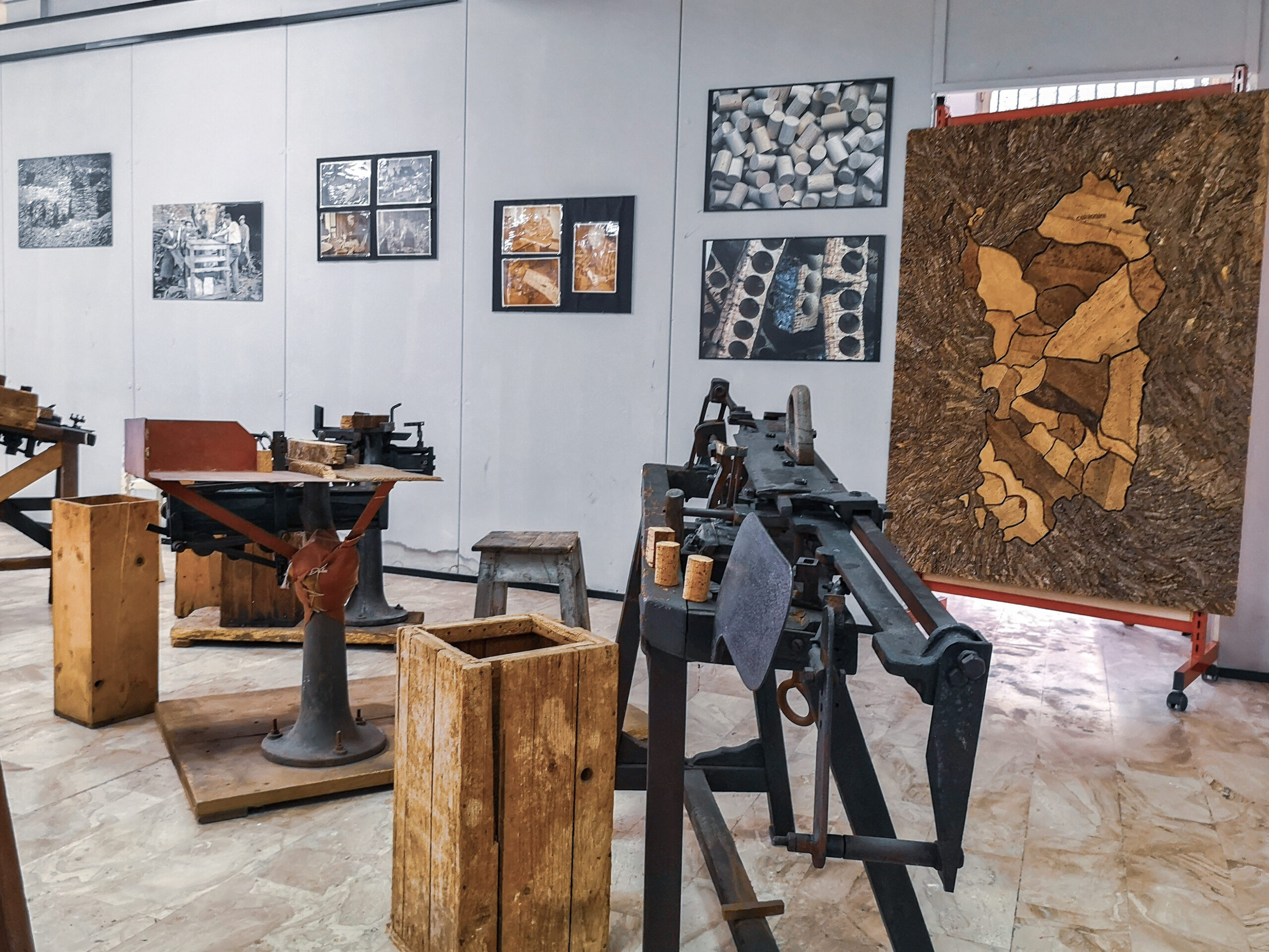 Blick in den Ausstellungsraum des Korkmuseums von Calangianus mit historischen Maschinen, Holzkisten und einer Kork-Karte von Sardinien