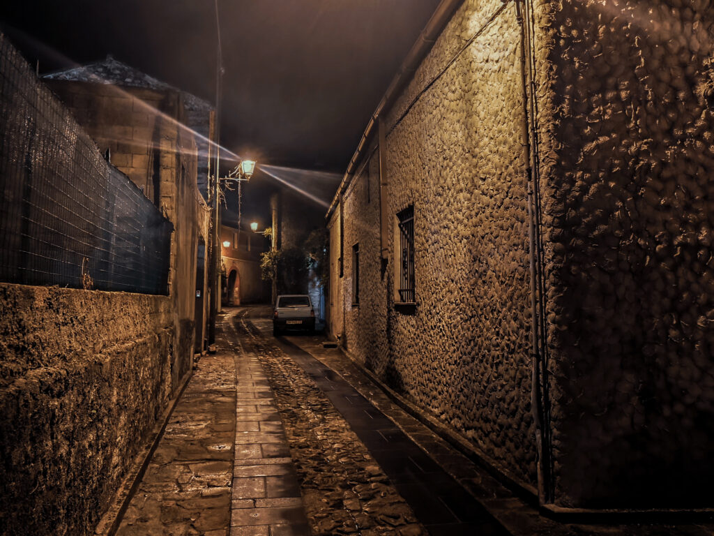 Schmale Gasse mit Kopfsteinpflaster in einem sardischen Dorf bei Nacht