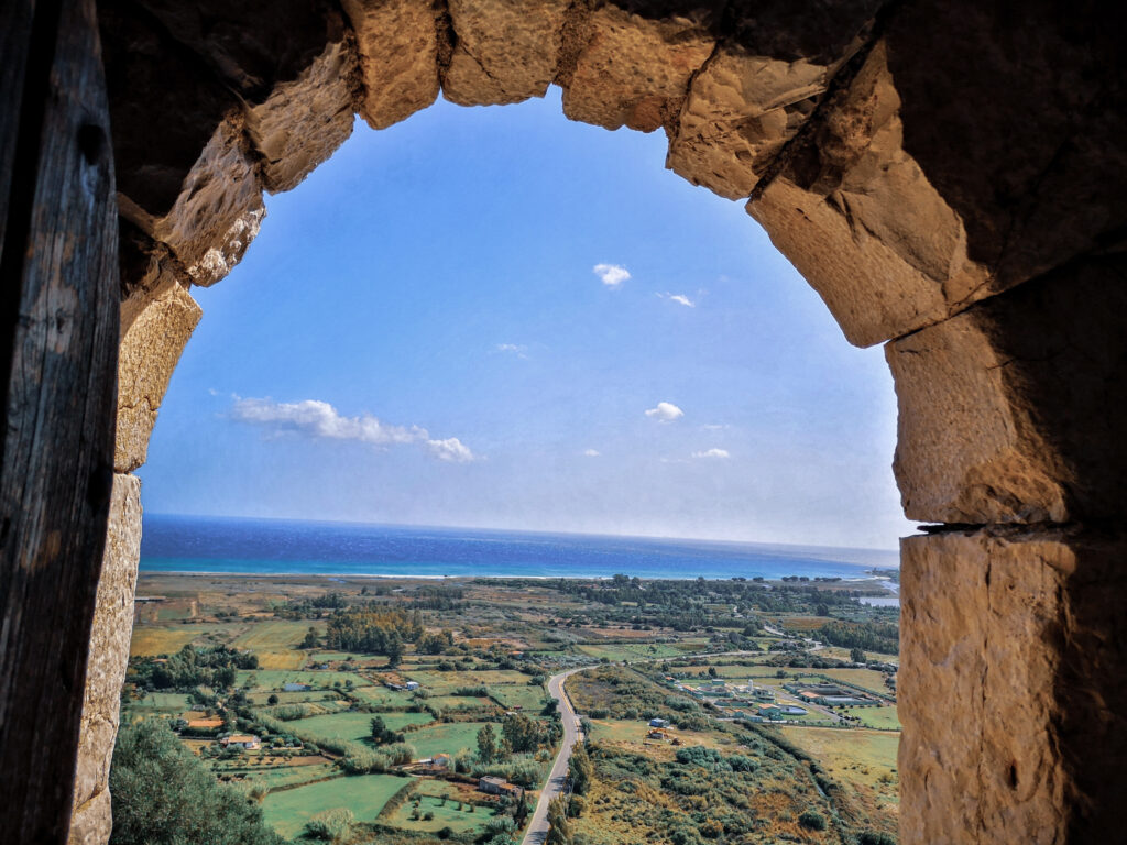 Aussicht Sardinien mit Blick durch eine Fensterluke auf Posada in Richtung Meer und Landschaft