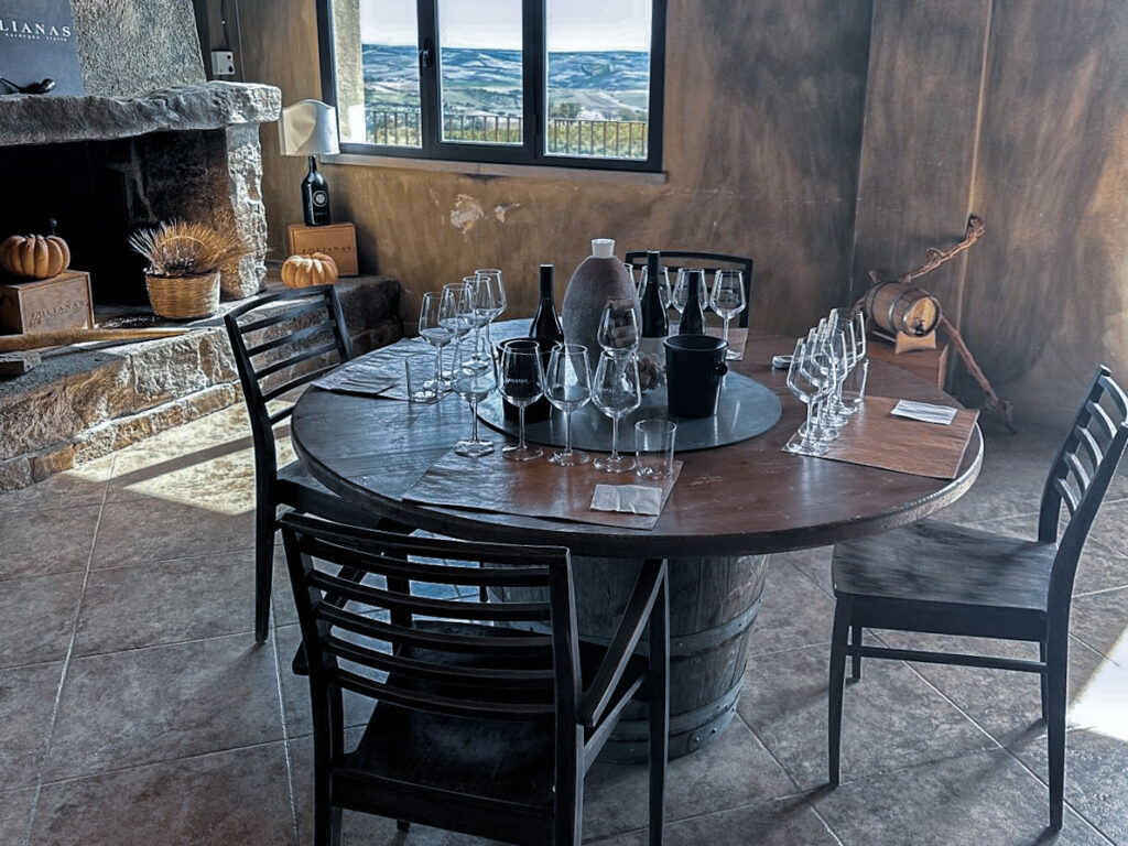 Ein runder Tisch mit vielen Weingläsern und Weinen bei einer Verkostung auf dem Weingut Olianas auf Sardinien