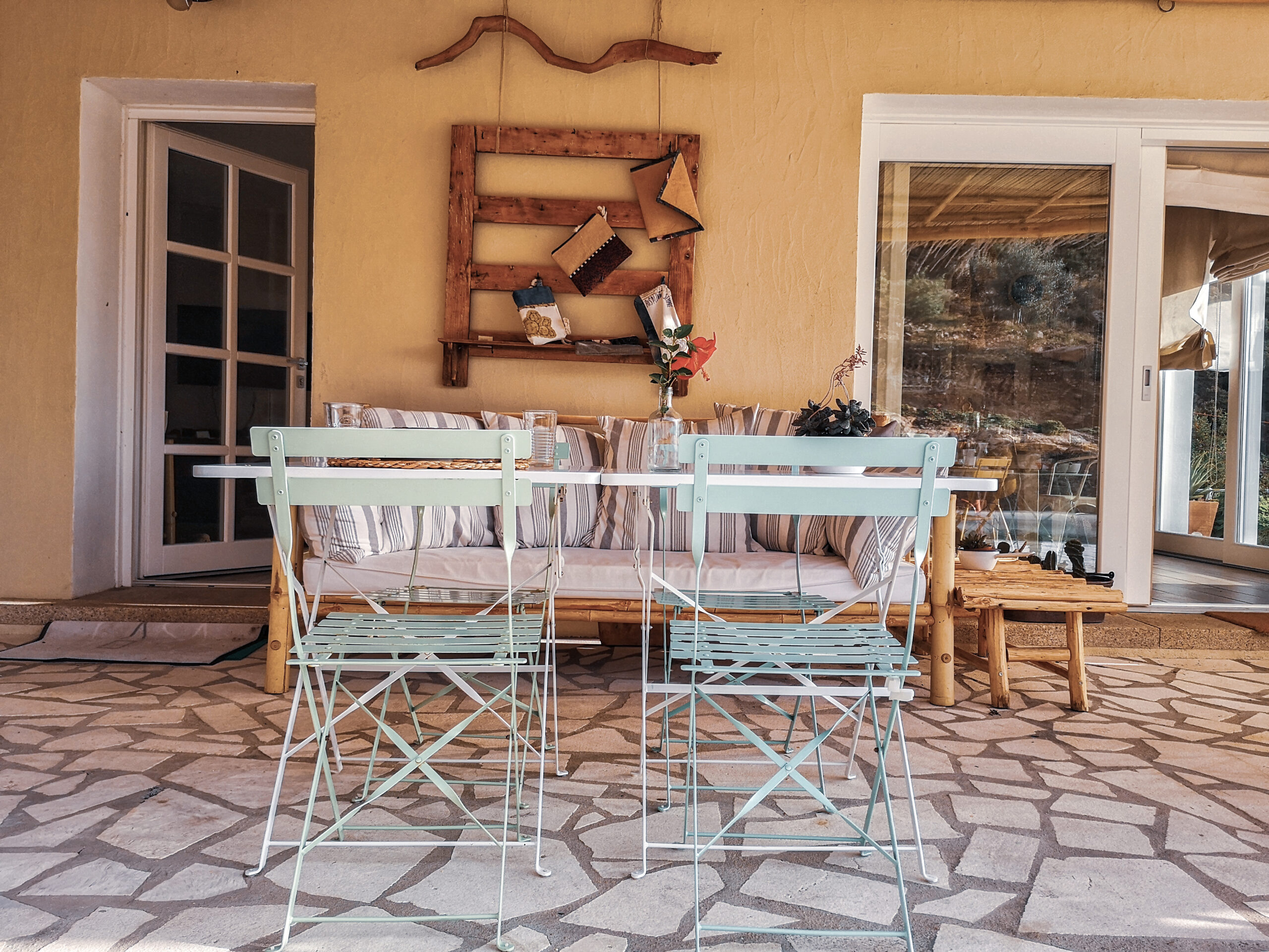 Terrasse mit bunten Stühlen, Tisch und gemütlichem Ambiente im Casa Stones auf Sardinien, einer außergewöhnlichen Unterkunft