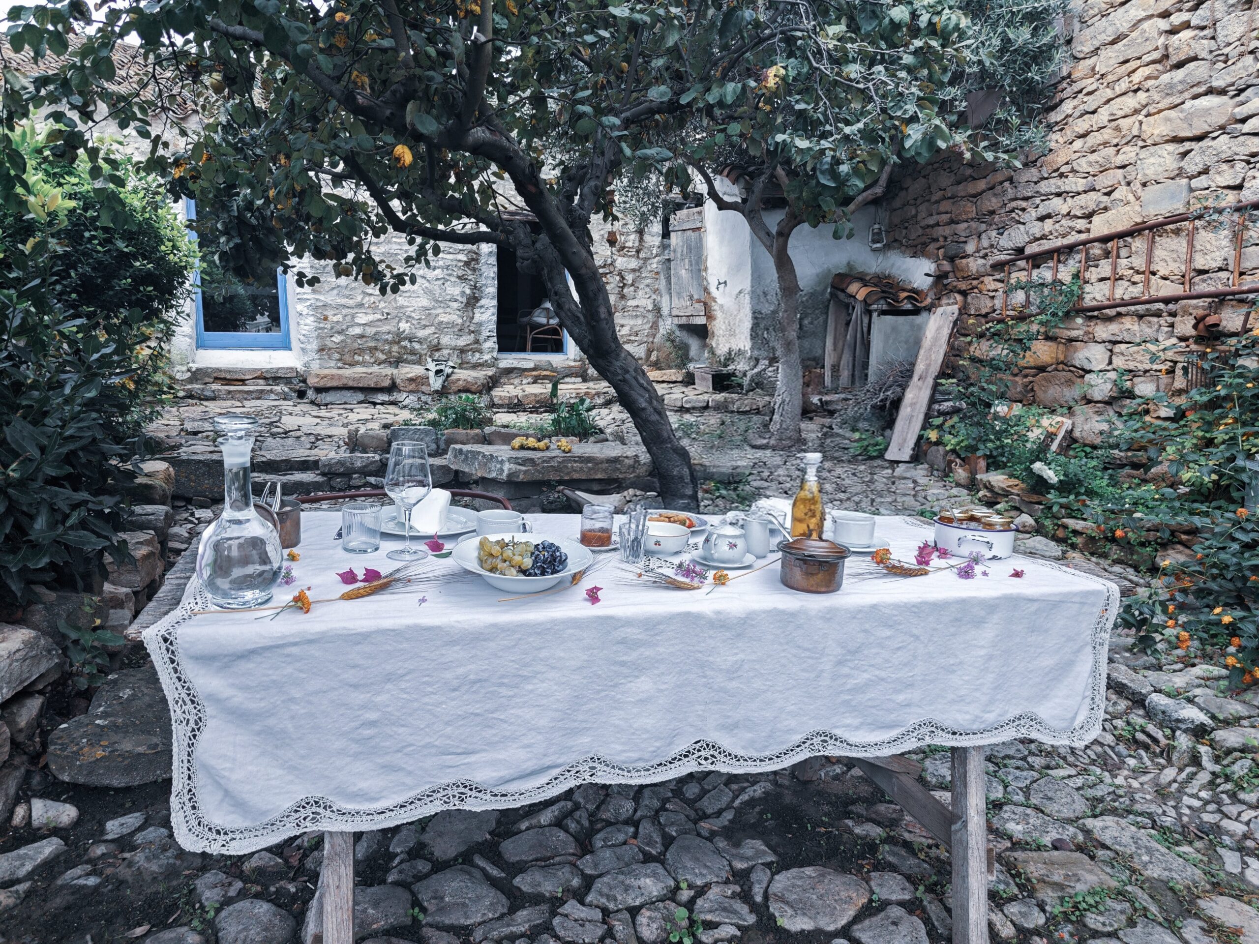 Eingangsbereich mit gedecktem Frühstückstisch im Vorgarten der Unterkunft Mario Cesare, außergewöhnliche Unterkunft auf Sardinien