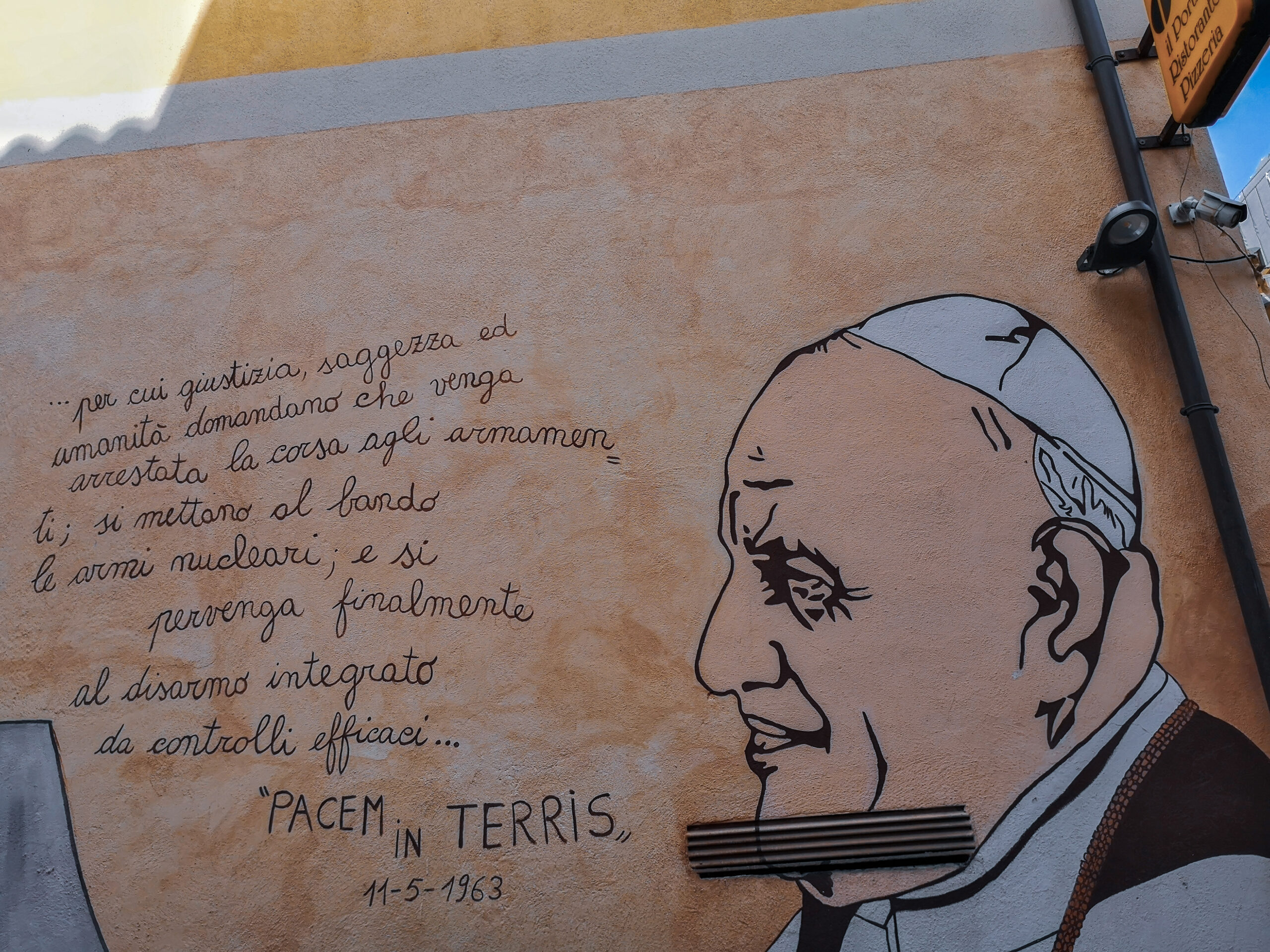 Wandgemälde in Orgosolo mit Papstportrait und Textauszug aus „Pacem in Terris“ von 1963