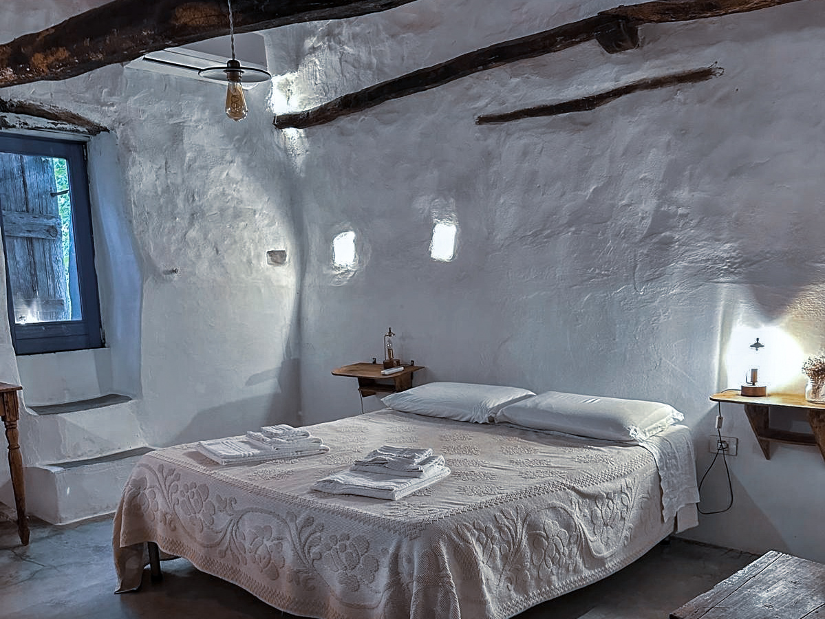 Blick ins Schlafzimmer mit Bett und rustikalem Ambiente in der Unterkunft Mario Cesare auf Sardinien