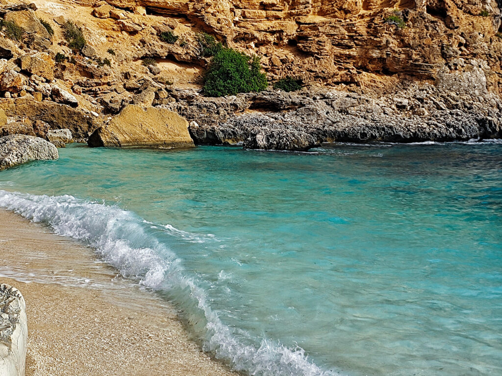 Türkisblaues Wasser und kleiner Strand in einer Bucht am Golfo di Orosei auf Sardinien