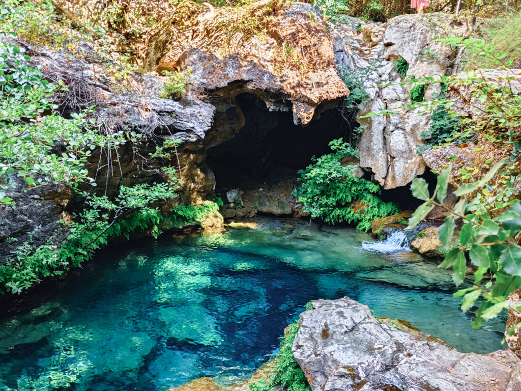 Piscine Naturali auf Sardinien mit türkisblauem Wasser, Felsen und kleiner Höhle im Landesinneren