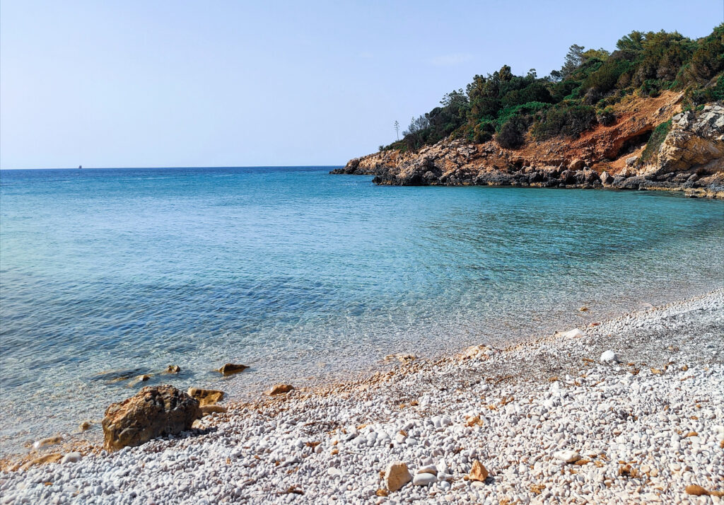 Ruhige Bucht auf Sardinien im Juli mit klarem Wasser und hellem Kiesstrand