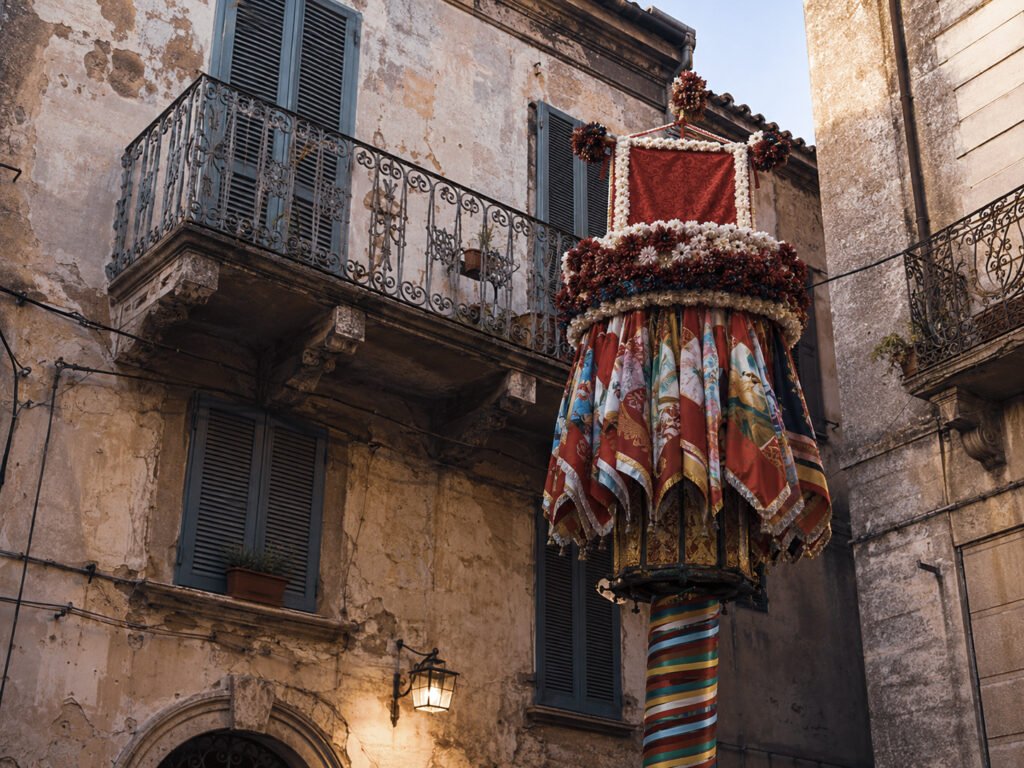 Festlich geschmückter Candeliere vor historischen Häuserfassaden in Sassari