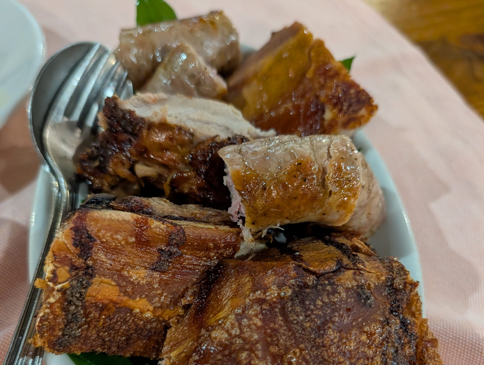 Knusprig gebratenes Porceddu mit Fleisch und krosser Haut auf einem Teller