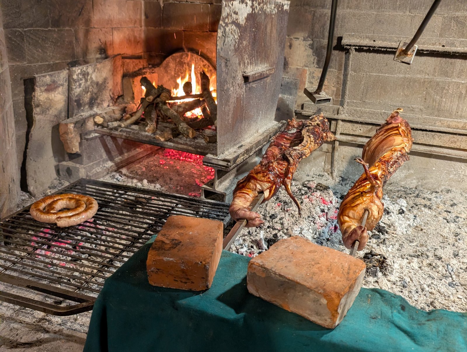 Porceddu am Spieß über der Glut bei traditioneller Zubereitung auf Sardinien